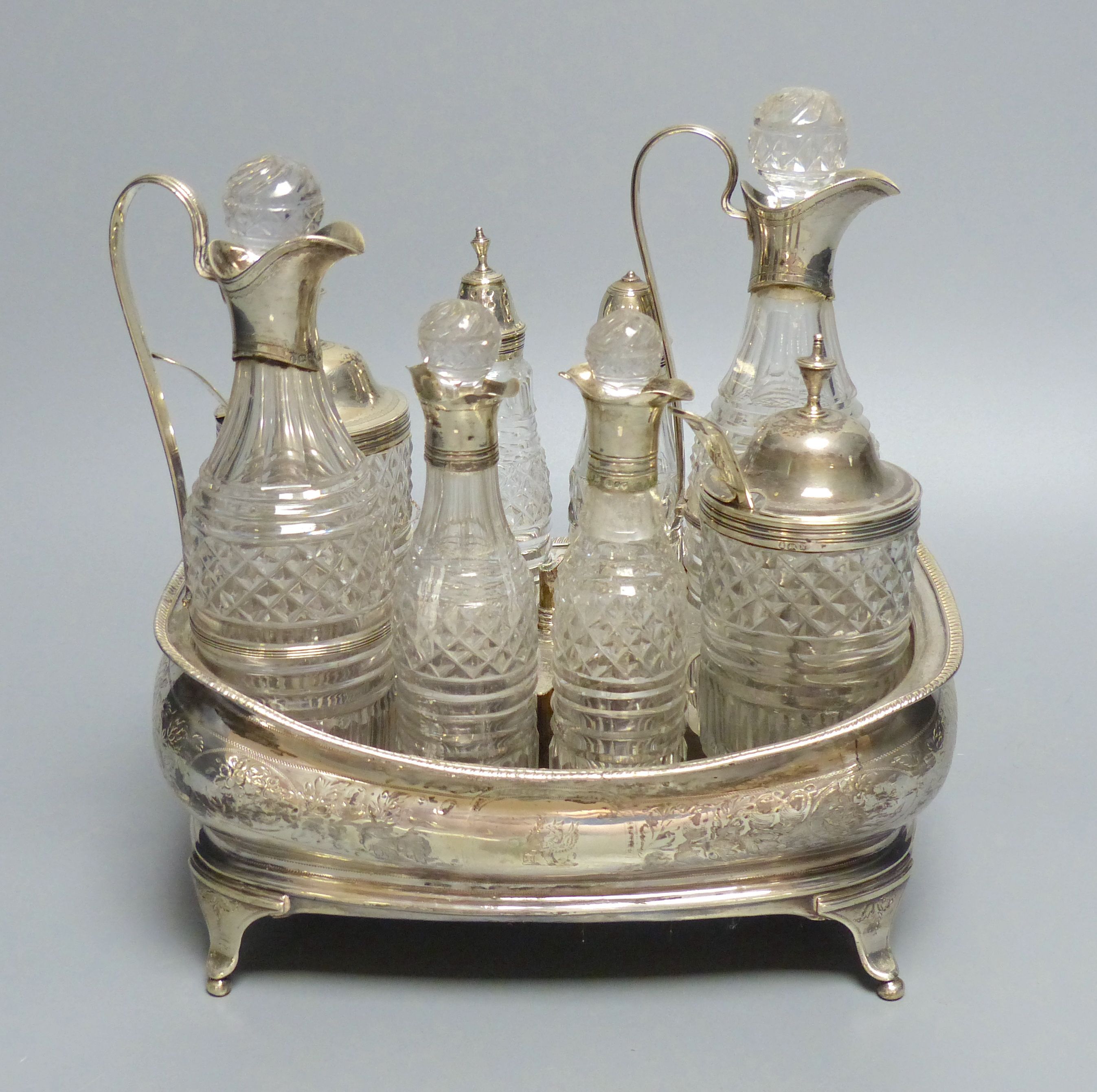 A George III silver cruet stand, with six matching cruets, London 1808, and two associated cruets, handle missing,